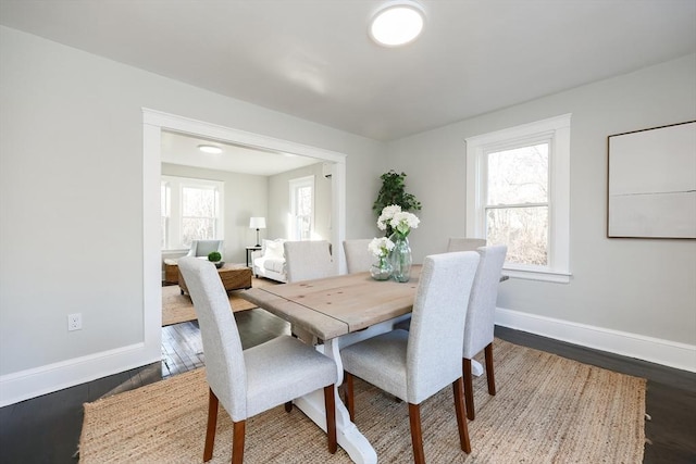 dining room featuring a healthy amount of sunlight and dark hardwood / wood-style flooring