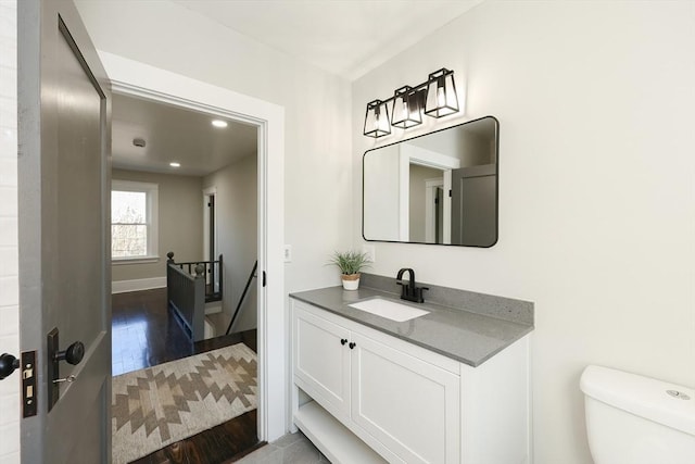 bathroom with hardwood / wood-style floors, vanity, and toilet