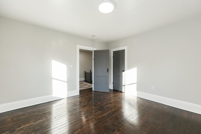 unfurnished room with dark wood-type flooring