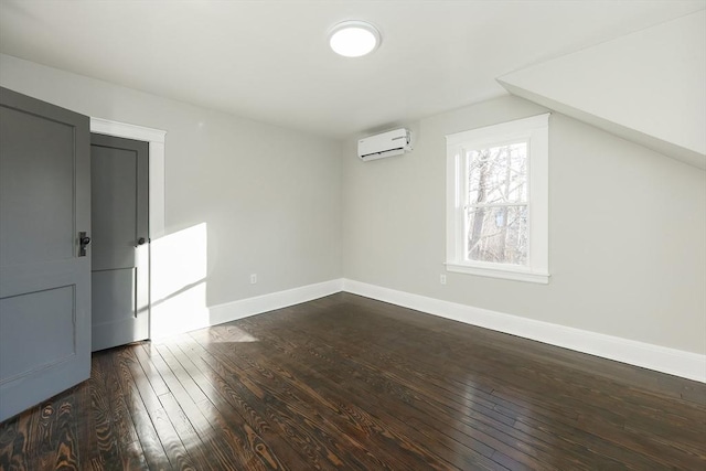 additional living space featuring a wall mounted AC and dark wood-type flooring