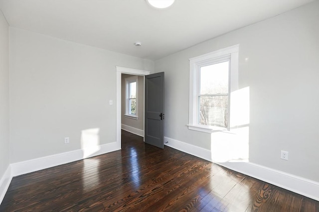 empty room with dark hardwood / wood-style flooring