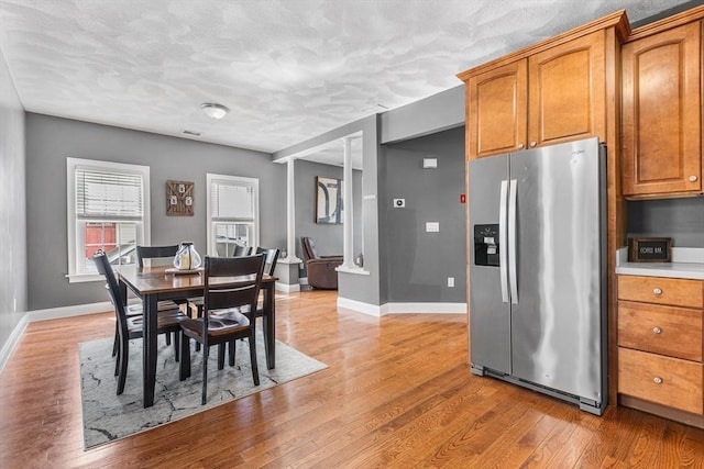 dining area with light wood-style floors, visible vents, and baseboards