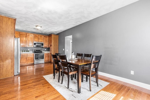 dining room featuring baseboards and wood finished floors
