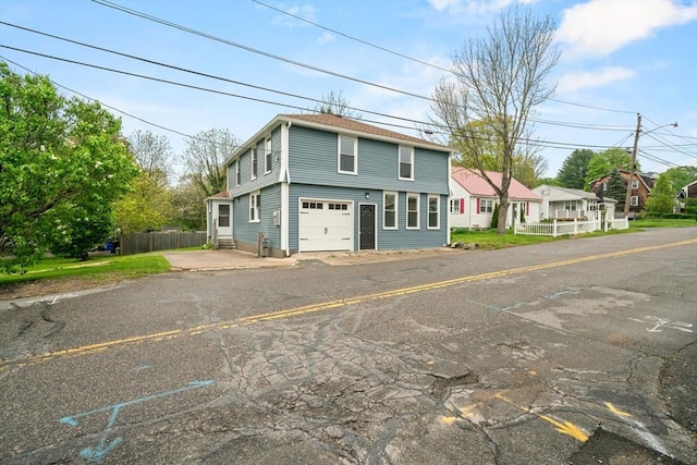 view of front of home featuring fence and a garage