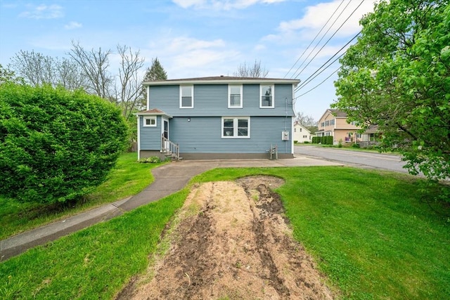 back of house featuring a lawn and entry steps