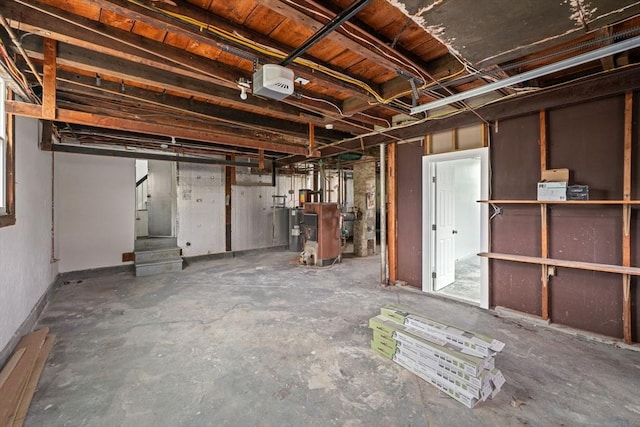 unfinished basement with water heater, a heating unit, and stairs