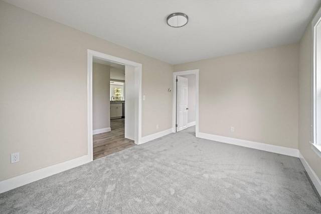 spare room featuring carpet and baseboards