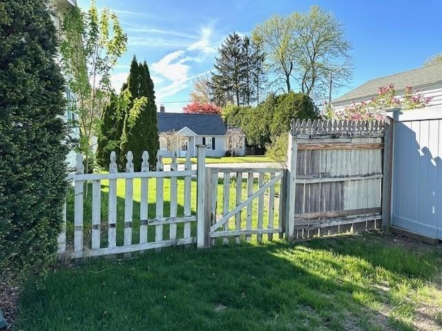 view of gate featuring fence and a yard