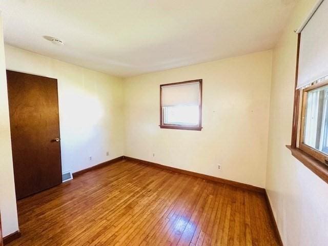 unfurnished room featuring wood-type flooring and baseboards