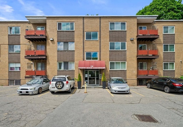 view of apartment building / complex with uncovered parking