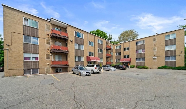 view of apartment building / complex featuring uncovered parking