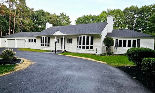 ranch-style home featuring a garage and a front lawn