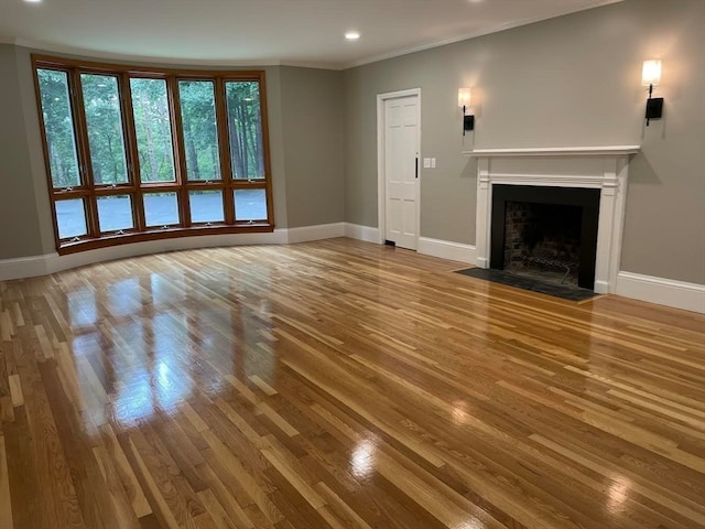 unfurnished living room with ornamental molding and hardwood / wood-style flooring