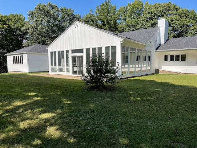 back of property with a lawn and a sunroom