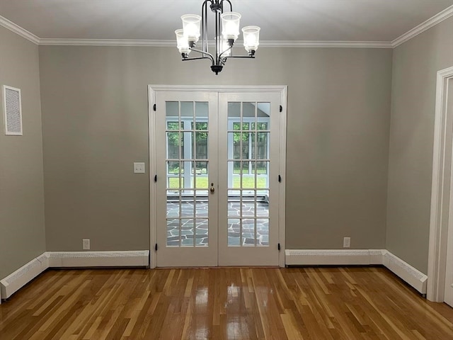 entryway with ornamental molding, hardwood / wood-style floors, and a notable chandelier