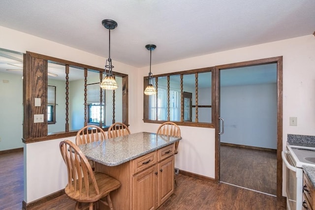 kitchen with light stone countertops, pendant lighting, dark wood-style flooring, a breakfast bar, and white electric stove
