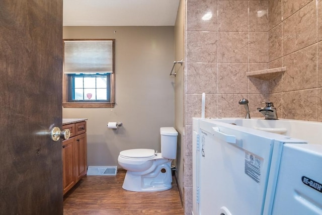 bathroom with toilet, baseboards, visible vents, vanity, and wood finished floors