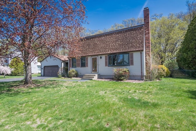 view of front of home featuring a chimney, driveway, a front lawn, and an attached garage