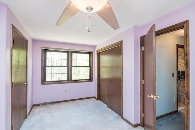 unfurnished bedroom featuring baseboards, a closet, visible vents, and light colored carpet