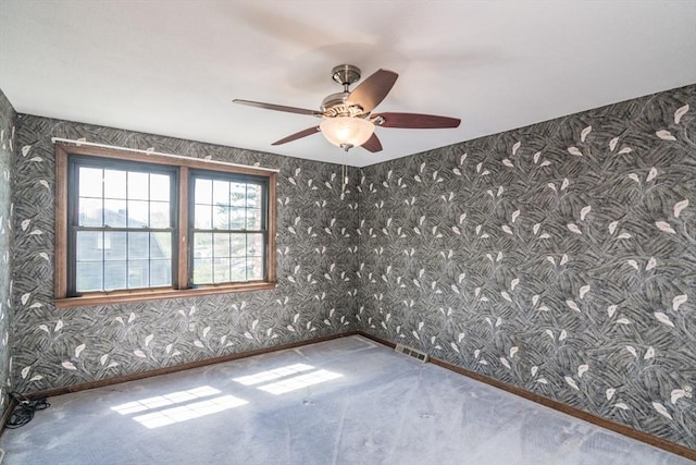 unfurnished room featuring wallpapered walls, visible vents, baseboards, and ceiling fan