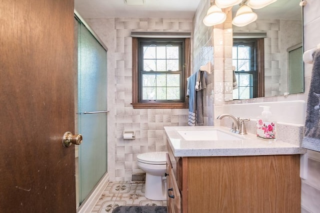 bathroom with a shower stall, tile walls, vanity, and toilet