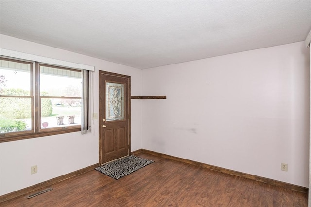 foyer featuring visible vents, wood finished floors, and baseboards