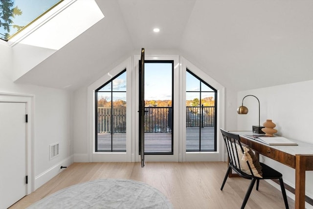 bonus room with a healthy amount of sunlight, vaulted ceiling with skylight, and light hardwood / wood-style floors