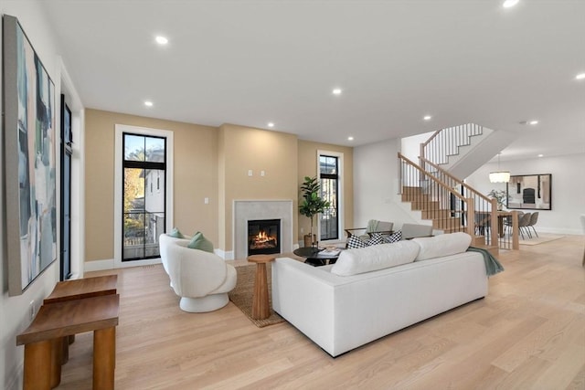 living room featuring light wood-type flooring, plenty of natural light, and a fireplace