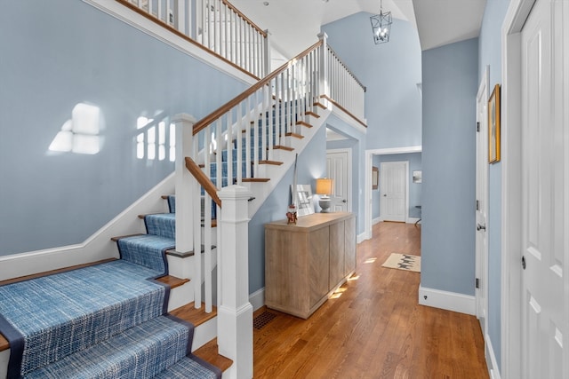 staircase featuring wood-type flooring and a towering ceiling