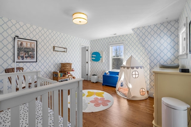 bedroom featuring a crib and hardwood / wood-style floors