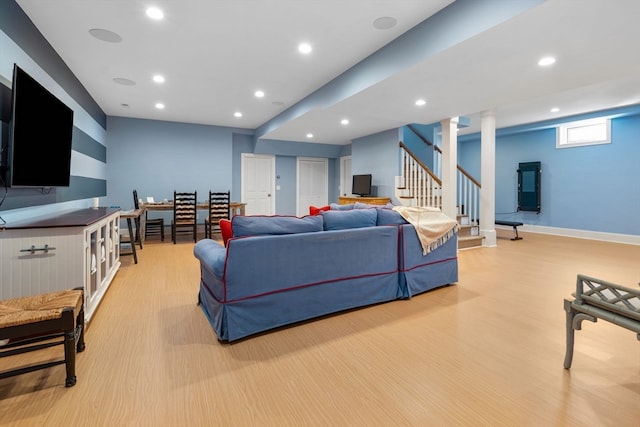 living room with light hardwood / wood-style floors and decorative columns