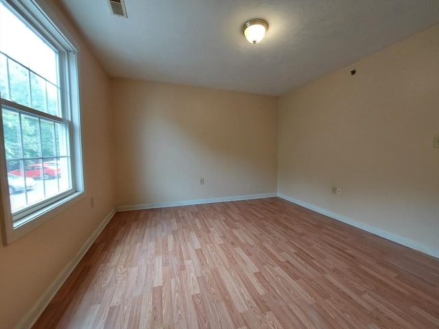 unfurnished room with light wood-type flooring and a wealth of natural light