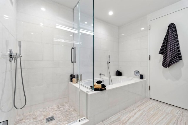 bathroom with a stall shower and a bath