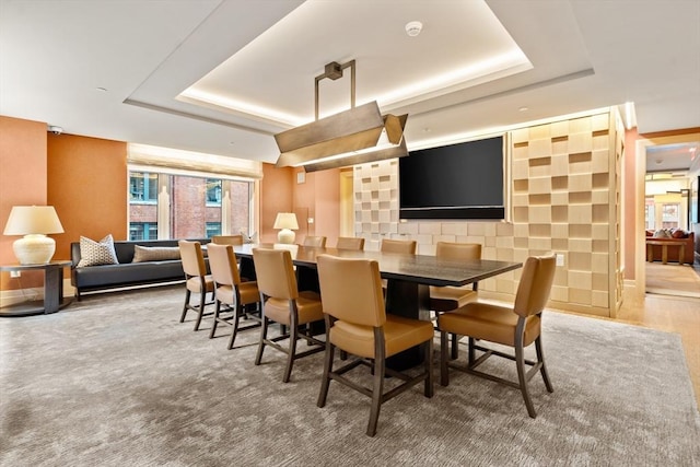 dining area with a raised ceiling and baseboards