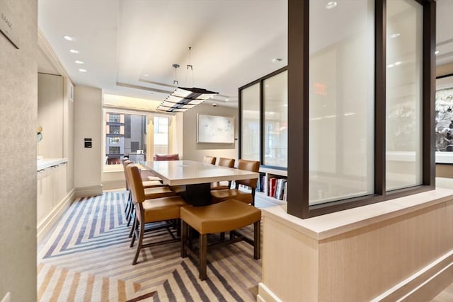 dining area featuring light carpet, recessed lighting, and a raised ceiling