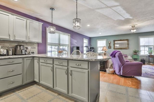 219-221 Wilson St Unit 1, Haverhill, MA 01832 - kitchen with a peninsula, open floor plan, recessed lighting, a chandelier, and decorative light fixtures