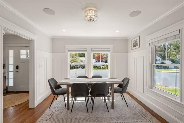 dining space with plenty of natural light, wood finished floors, and a decorative wall