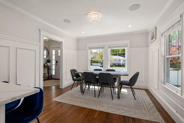 dining area with plenty of natural light, ornamental molding, dark wood-type flooring, and a decorative wall