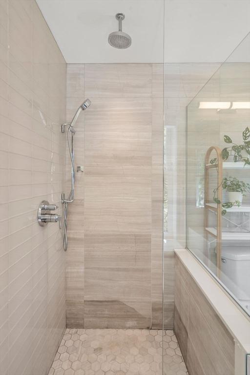 full bathroom featuring tile patterned flooring and tiled shower