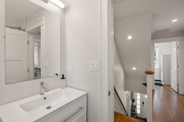 bathroom with vanity, recessed lighting, wood finished floors, and visible vents
