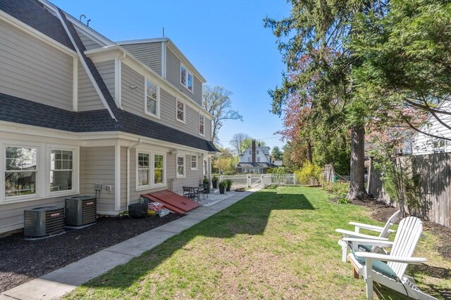 view of yard with a fenced backyard and central AC