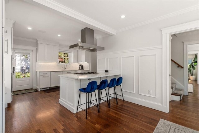 kitchen with a breakfast bar, white cabinetry, dishwasher, exhaust hood, and stainless steel gas stovetop