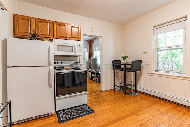 kitchen featuring baseboard heating, light wood-type flooring, and white appliances