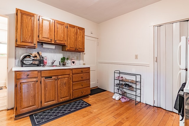 kitchen featuring decorative backsplash, sink, and light wood-type flooring