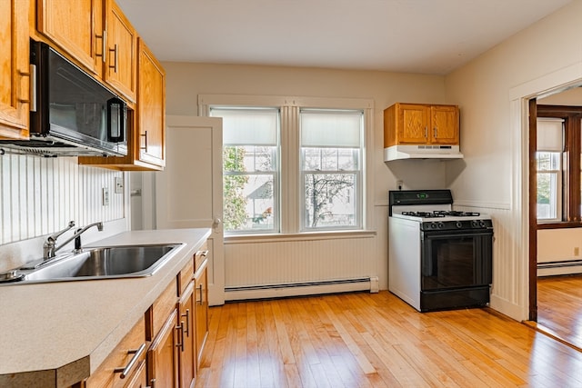 kitchen with sink, light hardwood / wood-style flooring, a baseboard heating unit, and gas range gas stove