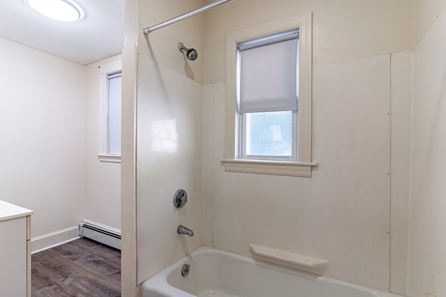 bathroom featuring vanity, hardwood / wood-style floors, baseboard heating, and  shower combination