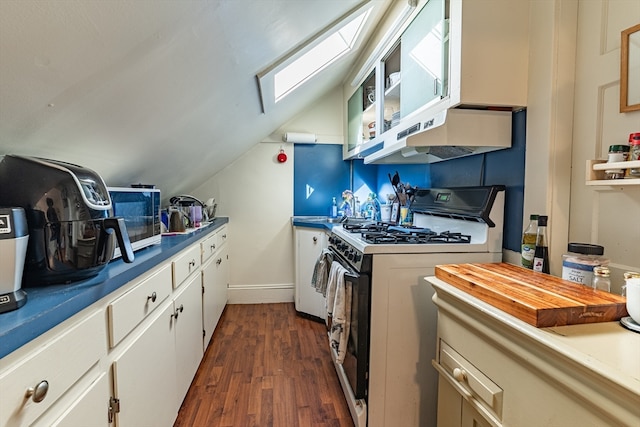 kitchen with dark wood-type flooring, lofted ceiling with skylight, white gas stove, and white cabinets