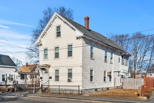 view of front of property featuring entry steps, fence, and a chimney