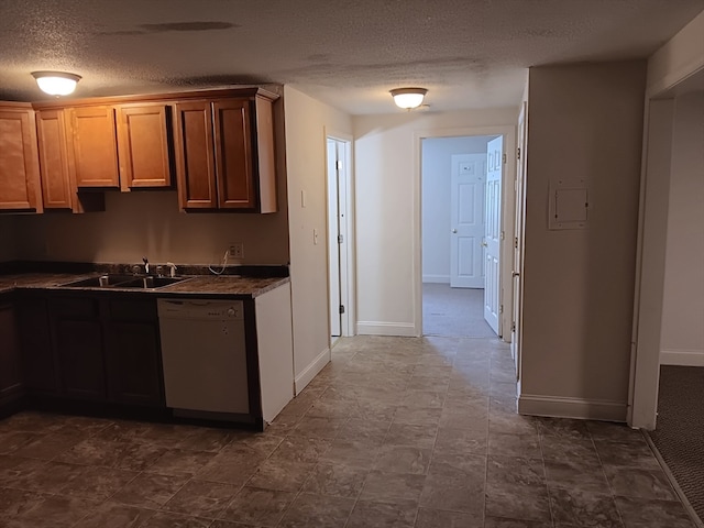 kitchen with tile floors, sink, dishwasher, and a textured ceiling