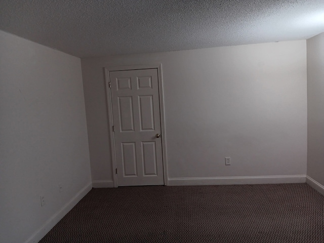 carpeted empty room featuring a textured ceiling